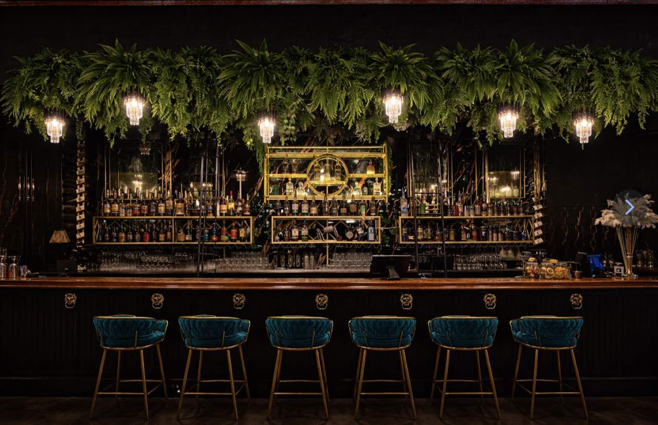 The Alibi bar: hanging ferns, crystal chandeliers and teal velvet stools