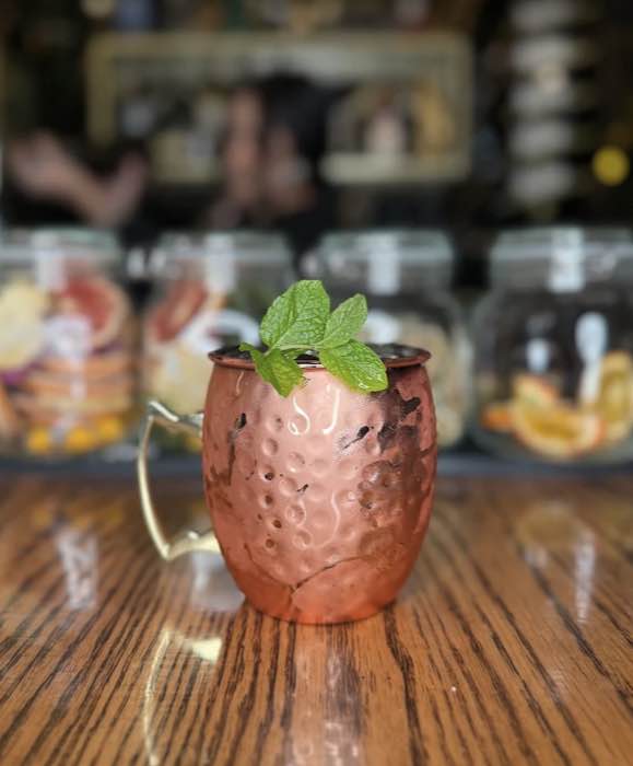 A hammered copper mule mug with fresh mint